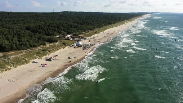 AERIAL: Rotating Shot of Surfers Riding Waves with Kites on a Sunny Day alt