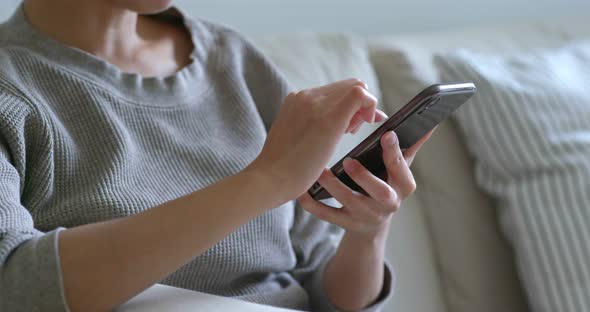 Woman use of mobile phone at home alt