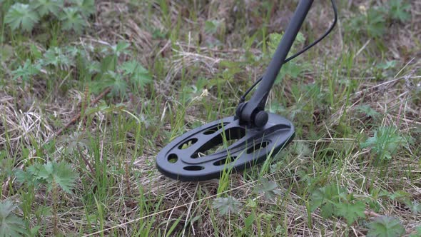 Treasure Hunter with Metal Detector Scanning Ground in Search of Artifacts