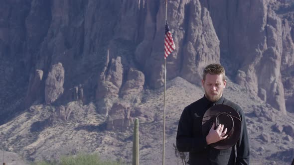 Cowboy paying respects in front of american flag alt