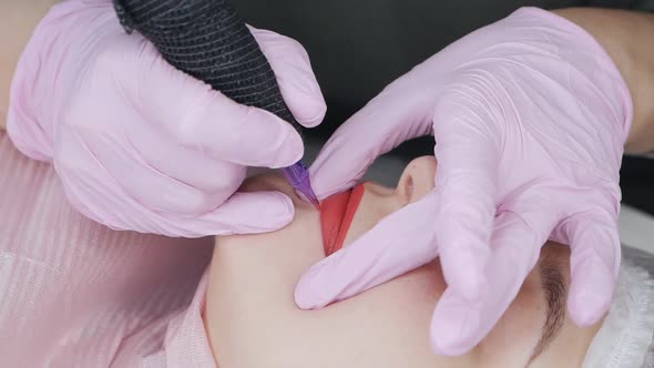 Permanent Lip Makeup Procedure with Applying Pigment Makeup on the Lips Using a Tattoo Machine