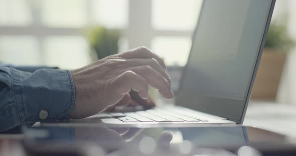 Man sitting at desk and working with a laptop