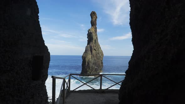 Walking through tunnel towards rocky ocean coast view alt