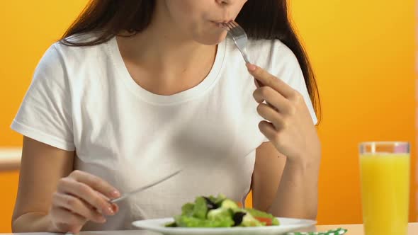 Beautiful Woman Enjoying Taste of Fresh Salad in Restaurant, Vegetarian Diet alt