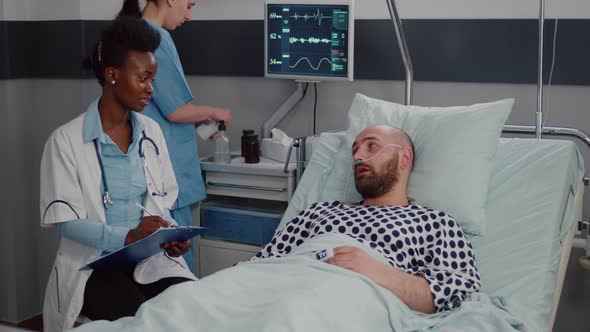 Afro American Doctor Discussing with Sick Man Writing Medical Treatment alt