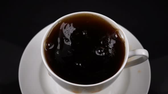 Sugar Cubes Dropped Into Coffee Creating Splash alt