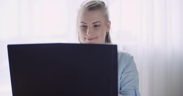 Smiling Woman Working on Laptop at Home Office. Businesswoman Typing on Computer Keyboard. alt