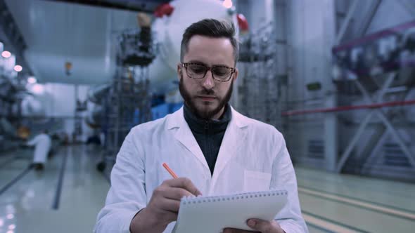 Engineer of Industry Four Makes Facility Technical Inspection in Large Hangar alt