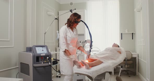 A Dermatologist Doctor Makes a Laser Treatment Procedure for a Patient's Skin alt