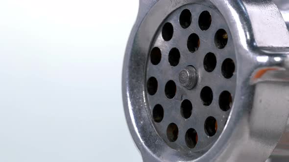 Carrots Are Scrolled Through a Meat Grinder and It She Comes Out in Small Pieces Through Holes alt