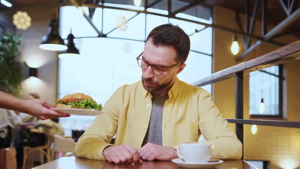 the Guy is Disappointed with Stale and Tasteless Food in the Restaurant and Complains to the Waiter alt