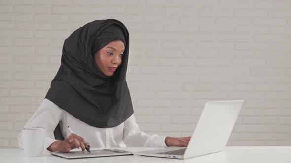 Woman Working on Digital Tablet and Laptop alt