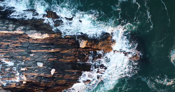 Aerial shot of the waves hitting the rock in Camden Maine USA as the sun set alt