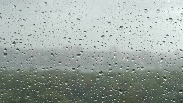 Drop flows down on a window in a rain