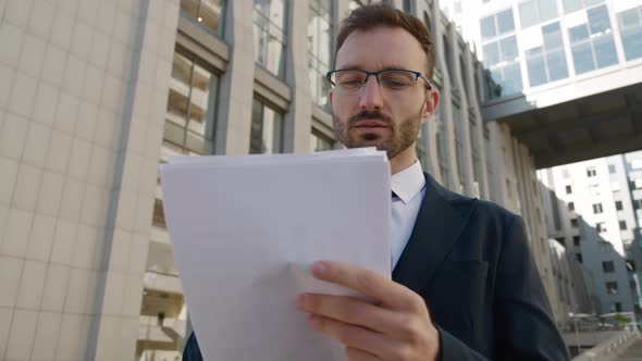 Confident Male Businessman in Eyeglasses and Formal Suit Standing Outdoors at Downtown District alt