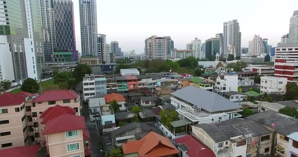 Flying over an under developed area with the Bangkok Skyline in the Background. alt