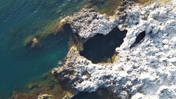 Drone footage of rock beach close up to sea