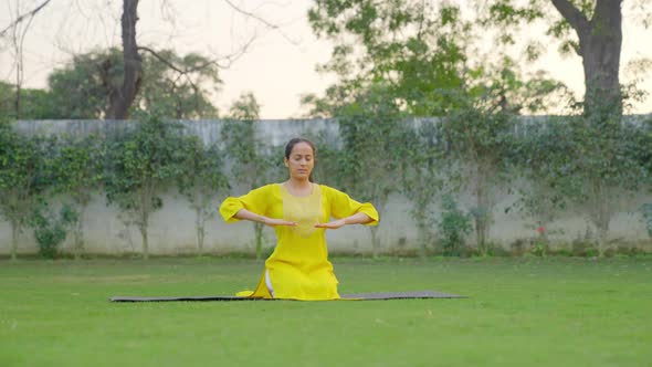 Yoga teacher teaching breathe in breathe out exercise in a park alt