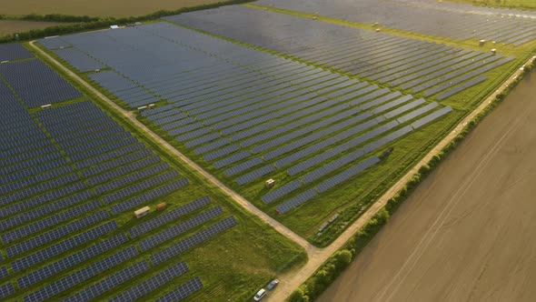 Aerial view of big sustainable electric power plant with rows of solar photovoltaic panels alt