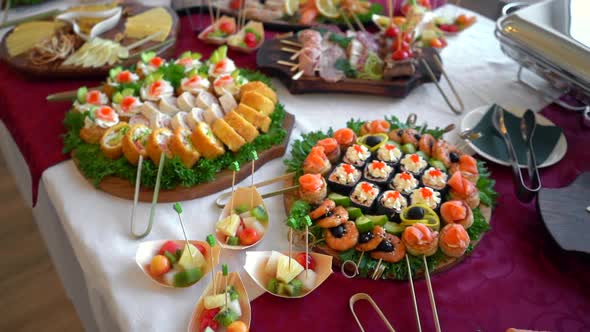 A set of seafood rolls with fish, caviar, shrimps and cream cheese on a buffet table