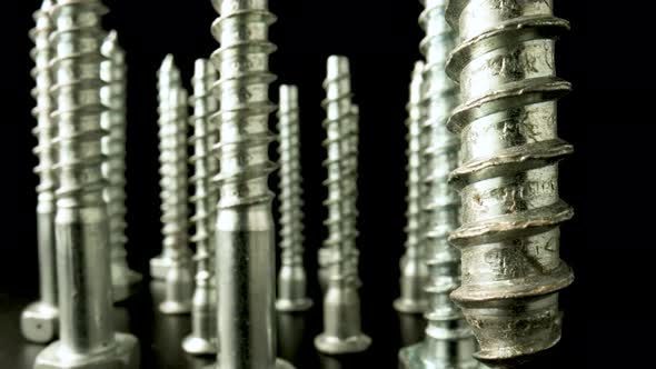 Screws Metal Threaded Bolts Fasteners Rotating on Isolated Black Background alt