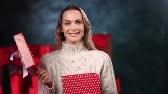 Portrait Woman Opening Festive Red Wrapped Gift Box Smiling Positive Emotion Posing at Gray Studio alt