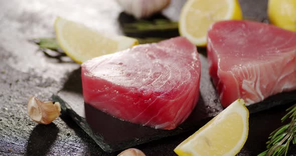 Tuna Raw Steaks on a Stone Board with Garlic and Lemon Rotate alt