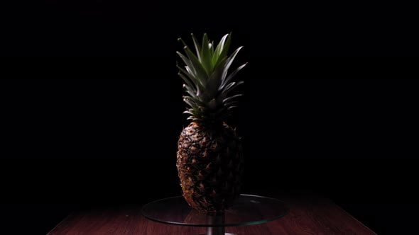 Pineapple Standing on a Table on a Black Background alt