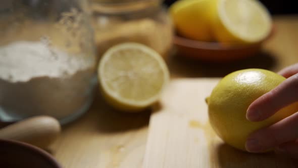 Woman Chef Cuts Fragrant Yellow Lemon on a Wooden Board