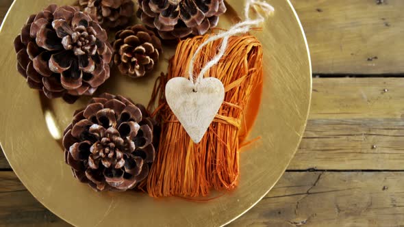 Pine cones and heart shape decoration in a plate alt