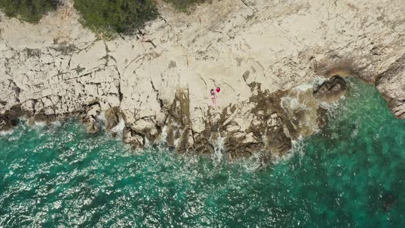 Aerial View Girl Lying on a Rock on Which the Waves Crash alt