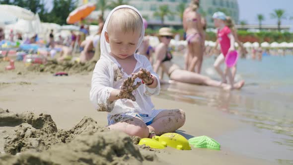 The Cute Little Boy Playing Toys with Sand at Sea Beach, Child Os on Vacation in Summer at the Beach alt