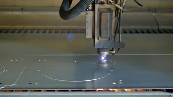 Laser cut machine while cutting the sheet metal with sparks and high precision alt
