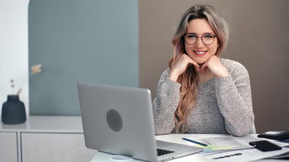 Cheerful Freelancer Woman Posing Table with Laptop and Paper alt