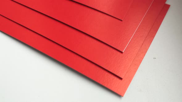 4k video, close-up of a stack of red paper rotating on a white background.