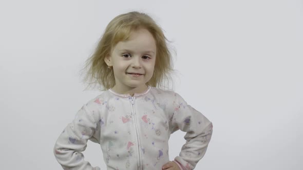 Little Beautiful Baby Girl in Pajama Looking at Camera. White Background alt
