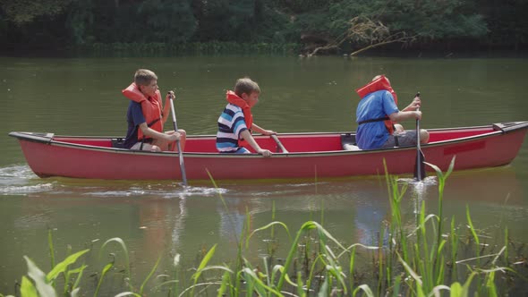 Kids at summer camp paddling a canoe