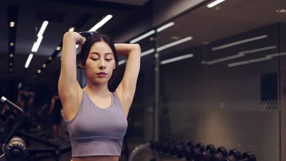 Asian young Female hands taking bodybuilding dumbbells in gym club alt