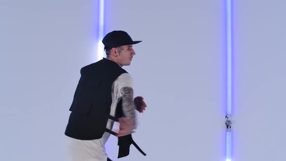 Professional Hip Hop Dancer Practicing Street Dance Elements Against Bright Neon Lights in Studio alt