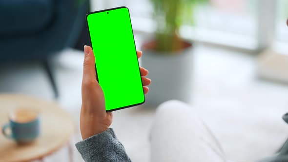 Woman at Home Using Smartphone with Green Mockup Screen in Vertical Mode alt