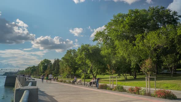 Timelapse a Crowd of People Walks Along the Promenade Near the River. alt