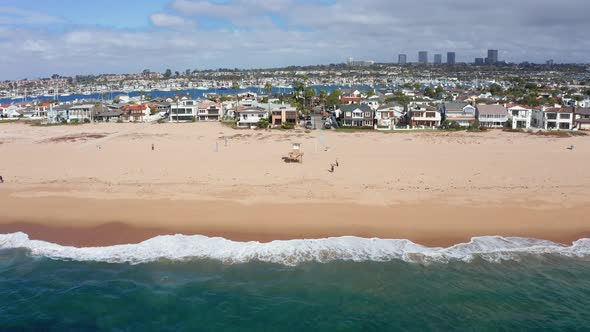 Newport beach shoreline, California. Beachfront condominium and villas, aerial zooming out alt