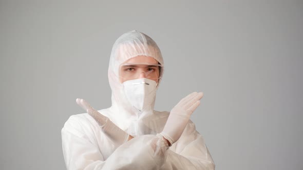 A Male Doctor in a Protective Medical Suit Shows a Forbidden Gesture