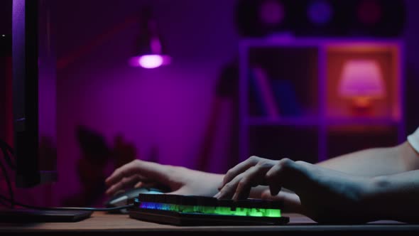 Gamer Typing on Backlight Keyboard Closeup Man Playing Video Game alt