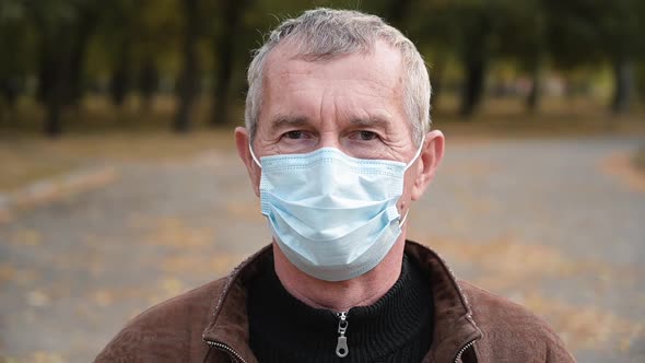 Close Up Portrait of Senior Man Wearing Medical Face Mask