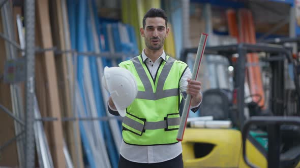 Happy Middle Eastern Employee Strethicng Hard Hat and Blueprint Looking at Camera Smiling alt