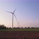 Windmills in a plowed field. Wind farm with turbine cables for wind energy. - VideoHive Item for Sale