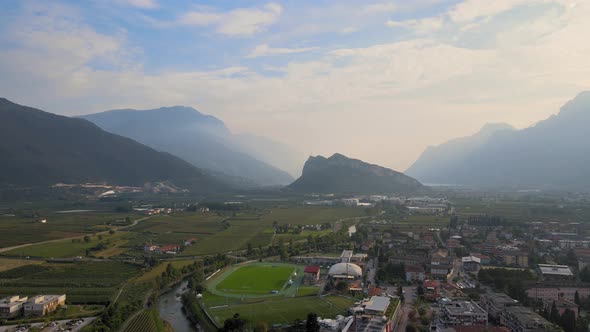 Aerial view of Riva del Garda during a sunny day. City overview with mountains and clouds. Shooting alt