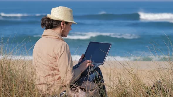 Freelancer Woman Working in Her Notebook on Beautiful Coastline alt