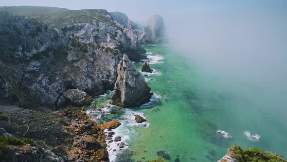 Rugged Cliff Coastline at Atlantic Ocean with Morning Fog in Sintra, Portugal